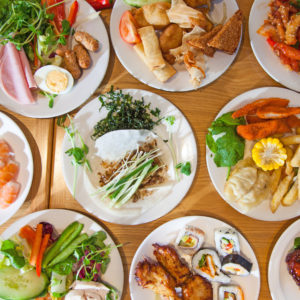 A selection of Chinese buffet foods served on a spread of white plates