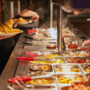 View along a Chinese buffet bar with people serving food